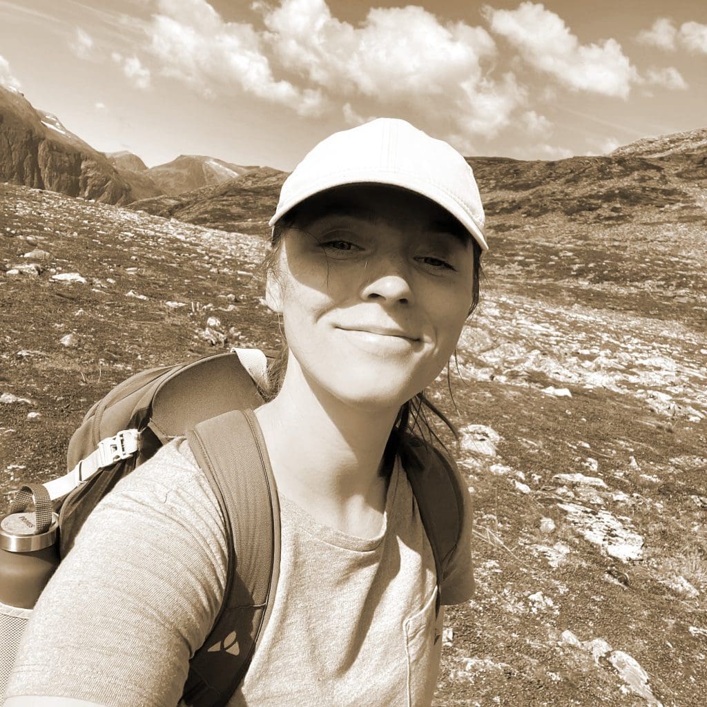 Diana Weickert mit Rucksack auf der Schulter. Sie ist beim Wandern.