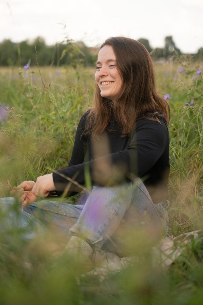 Diana Weickert sitzt im Gras und genießt die Natur.