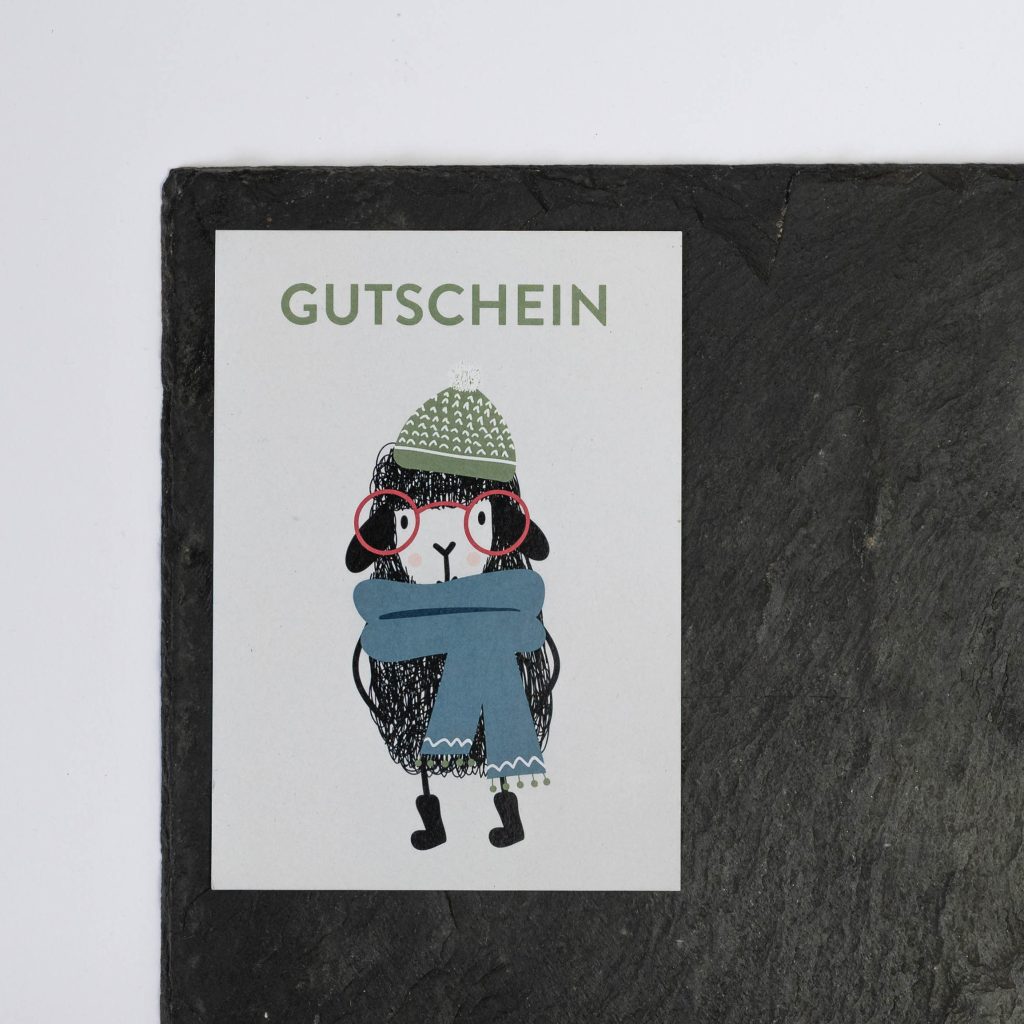 Strikkeart-Gutscheinkarte mit illustriertem Schaf. Das Schaf trägt einen gestrickten Schal.