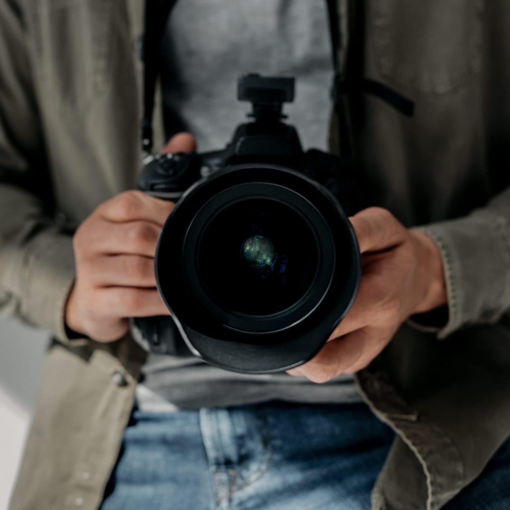 Der Fotograf hält seine Kamera in der Hand.