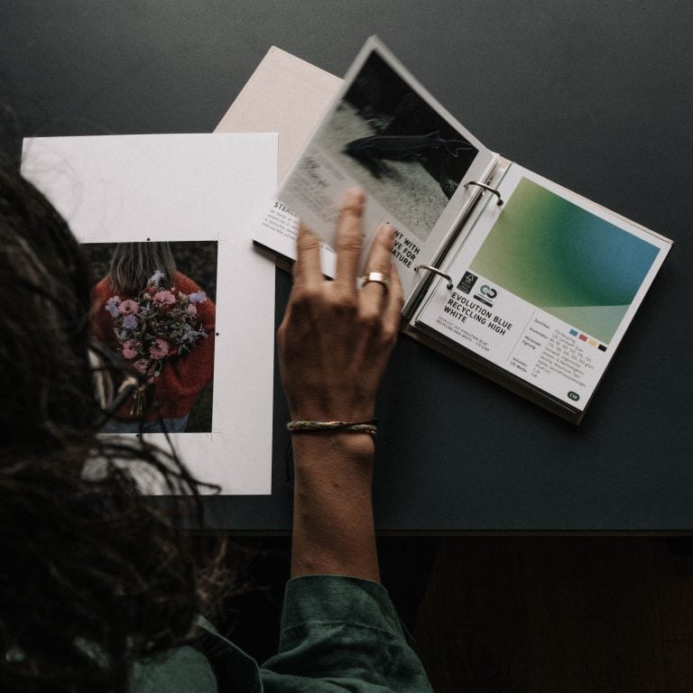 Barbara sucht ein passendes Papier für eine gestaltete Postkarte.